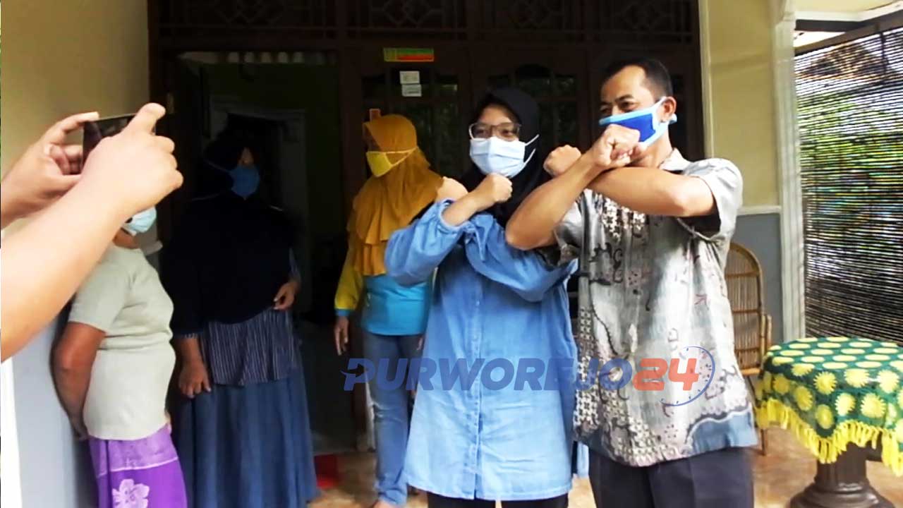 Dwi Rahayu, perawat yang sembuh dari positif Covid-19 berfoto bersama warga saat penyambutan kepulangan dari Rumah Sakit.