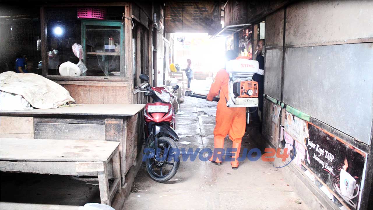 Petugas Dinas Kesehatan melakukan penymprotan disinfektan di pasar Suronegaran.