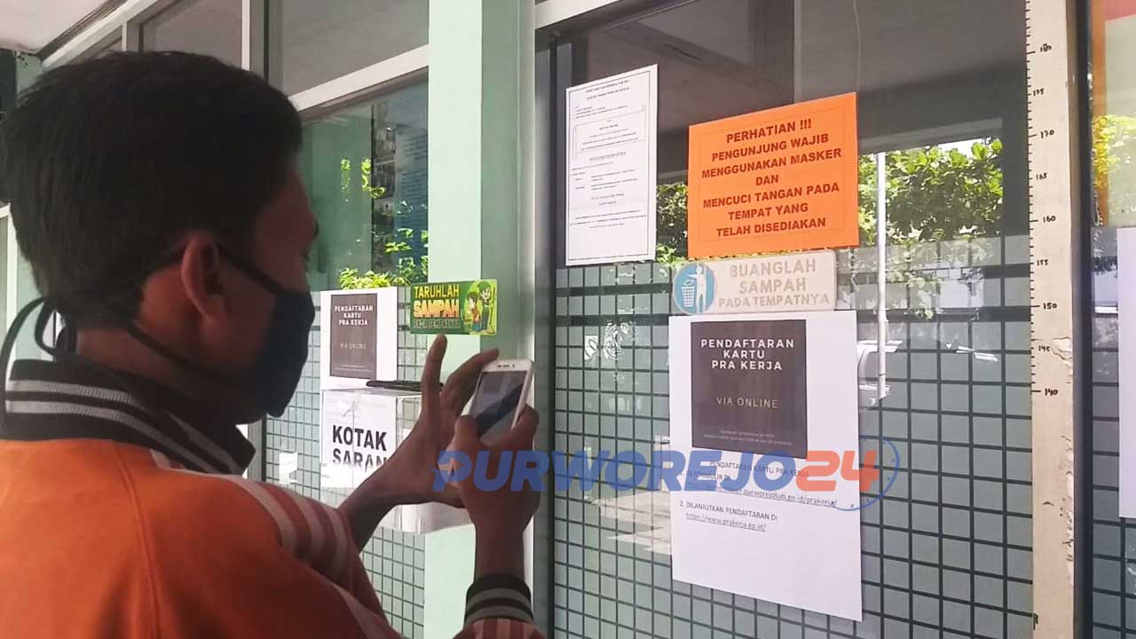 Seorang warga sedang membaca informasi di kantor Dinperinaker Kabupaten Purworejo