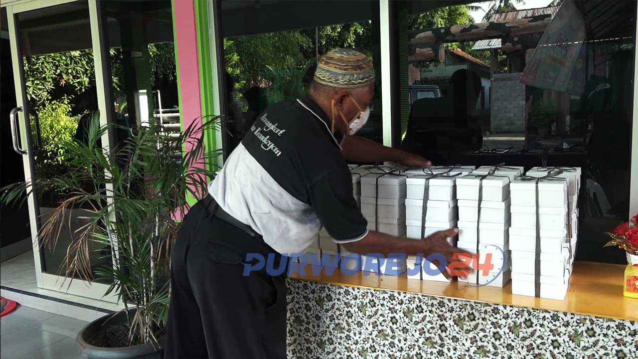 Perangkat Desa Krandegan merapikan makanan yang ada di Meja Anti Lapar