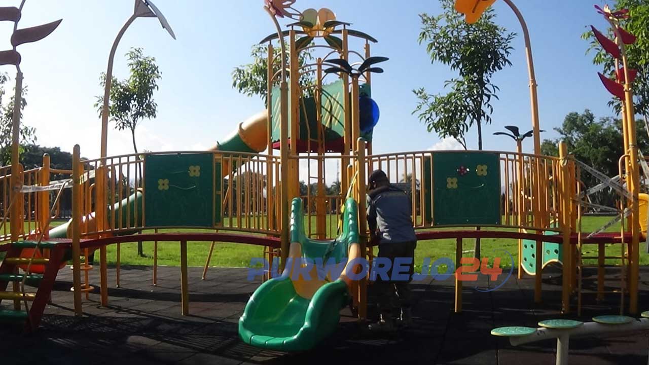 Petugas melepas pita pembatas di arena permainan anak di Alun-alun Purworejo. (12/6/2020)