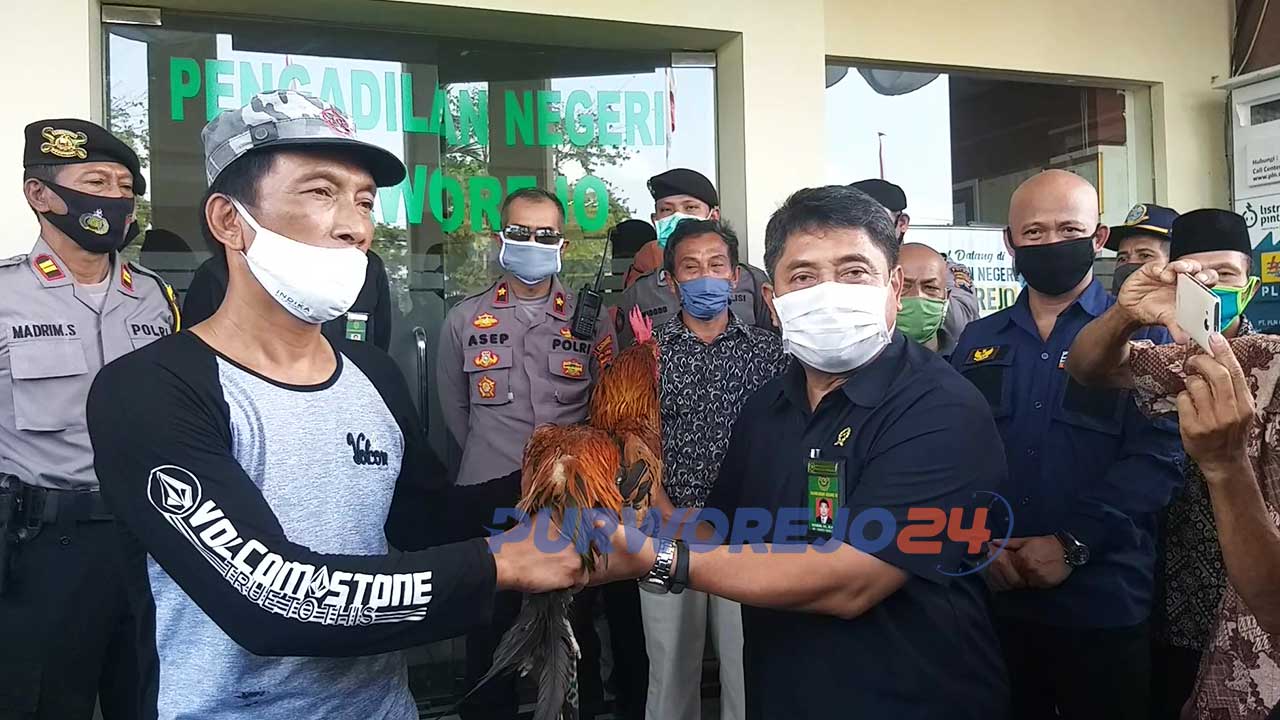 Perwakilan warga korban terdampak Proyek Bendung Bener menyerahkan seekor ayam jago kepada Ketua PengadilanNegeri Purworejo.