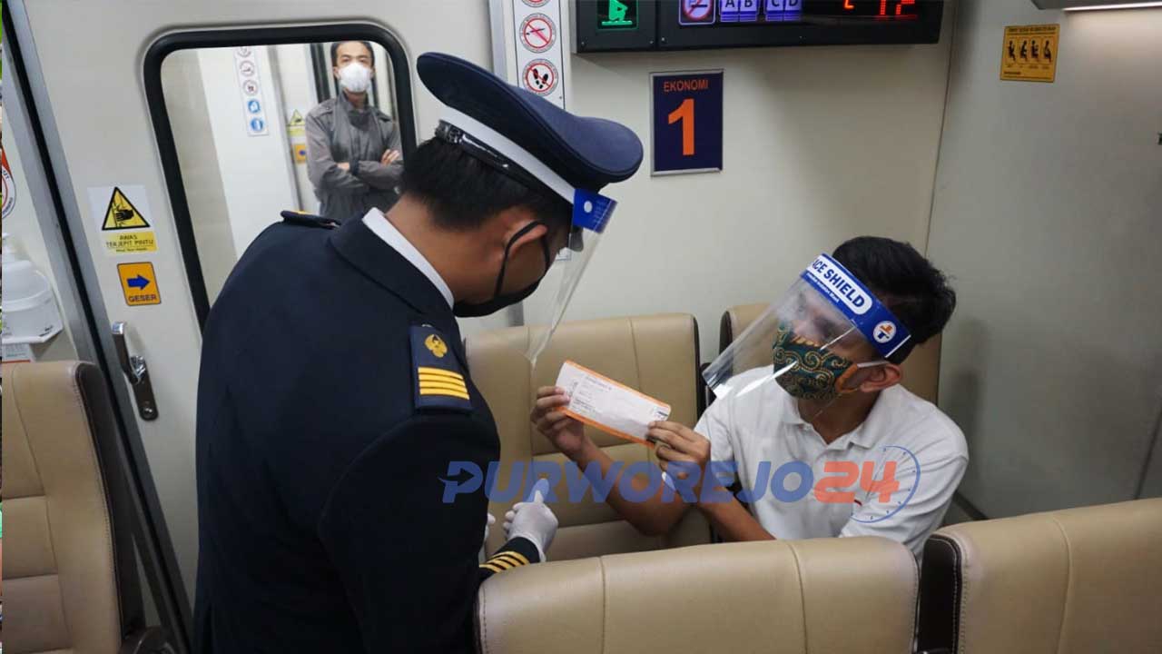 Seorang penumpang memperlihatkan tiket kepada petugas