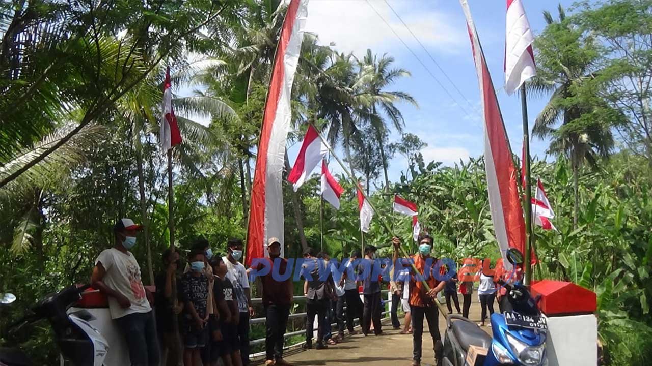 Warga memasnang puluhan bendera merah putih di jembatan Desa Dumpoh, Kecamatan Loano