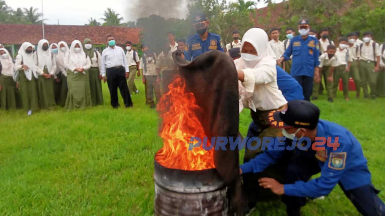 Seorang siswi SMP N 26 Purworejo dan Damkar Purworejo melakukan simulasi pemadaman api
