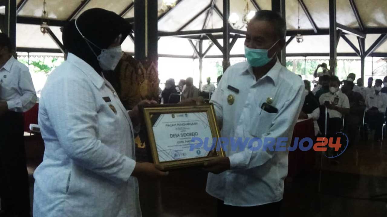 Wakil Bupati Yuli Hastuti menyerahkan piagam penghargaan Desa Inklusi tingkat Mentor kepada perwakilan dari Desa Kaliharjo, Kaligesing