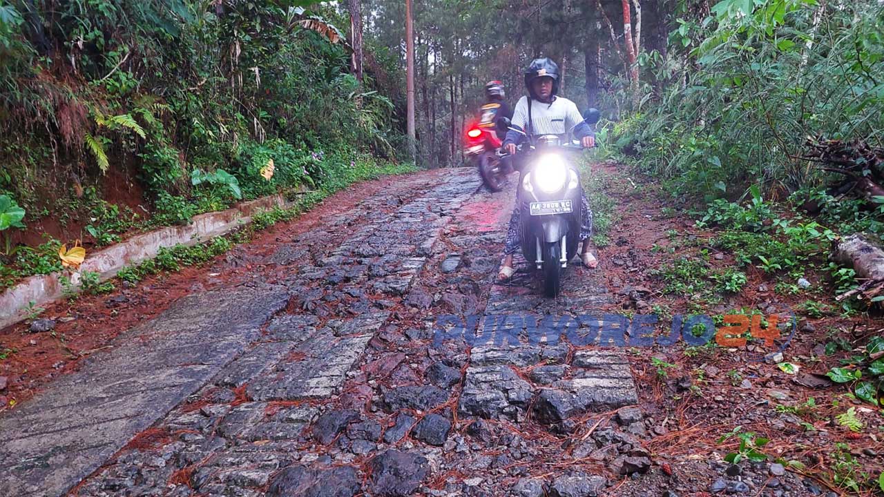 Warga melintasi jalan menuju Wisata Curug Putri di Desa Cepedak Kecamatan Bruno Kabupaten Purworejo yang rusak parah