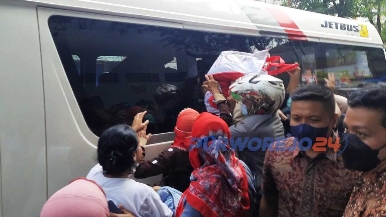 Warga berebut untuk mendaptkan bantuan sembako dari dalam mobil rombongan presiden Jokowi