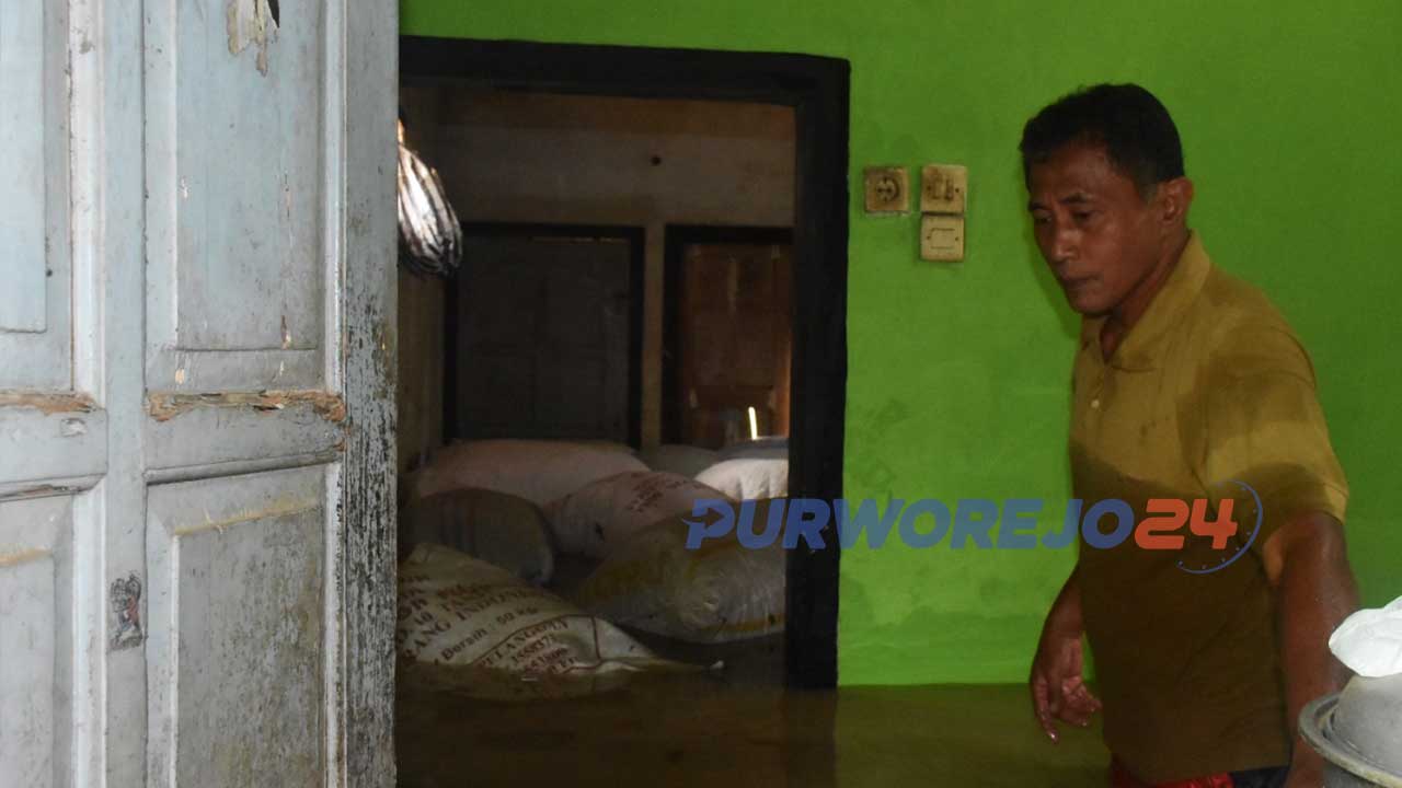 Heri Suroto sedang berusaha menyelamatkan barang pada saat banjir (istimewa)