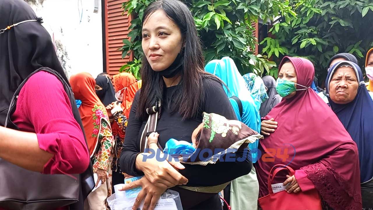 Dengan menggendong bayinya yang masih berumur kira-kira satu tahun, Ayu harus antre dengan ribuan masyarakat lainnya di Kantor Pos Purworejo.