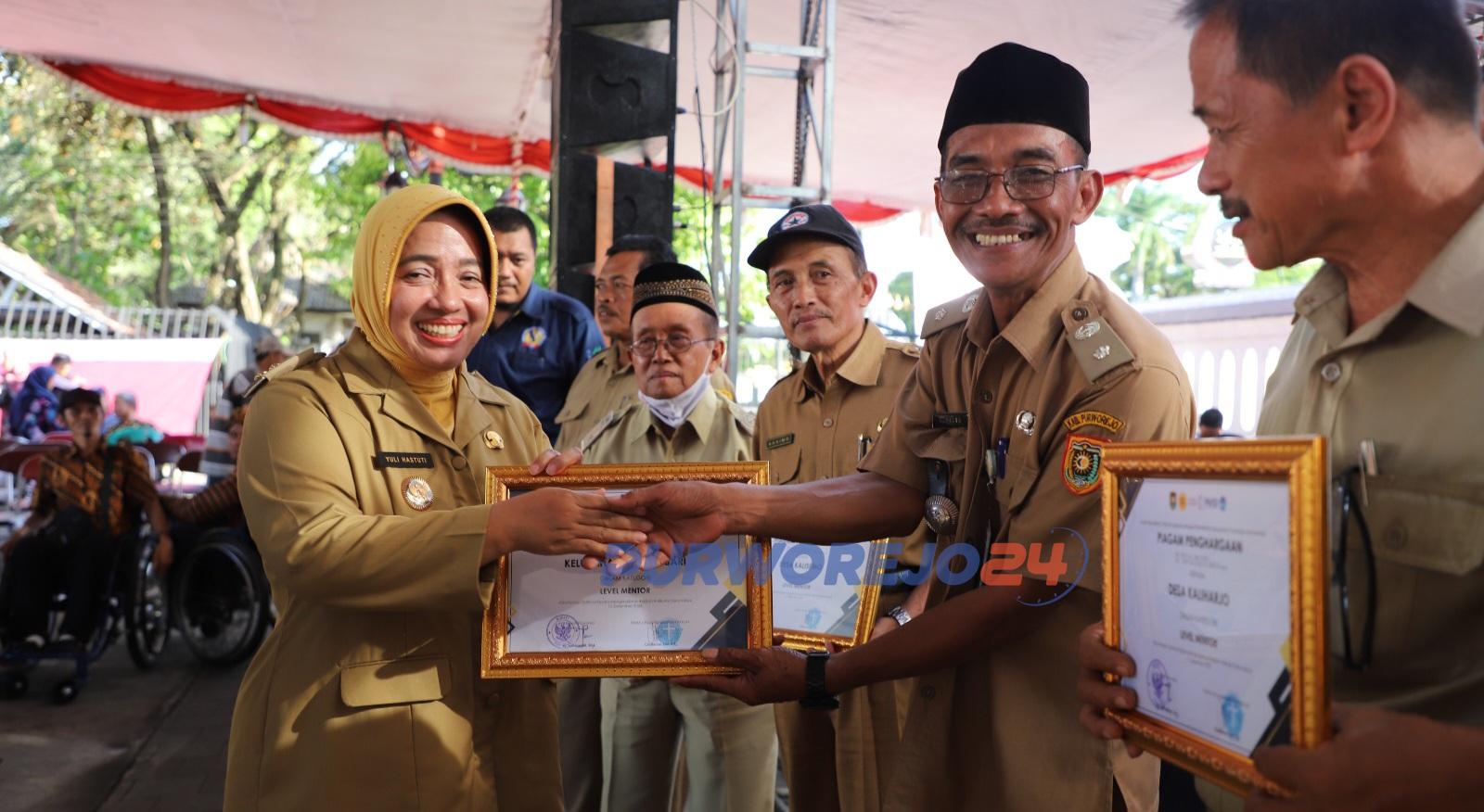 Plt Bupati Purworejo, Hj Yuli Hastuti SH menyerahkan penghargan kepada desa Inklusi dalam peringatan Hari Disabilitas Internasional di halaman Art Center Purworejo, pada Senin (11/12/20023)