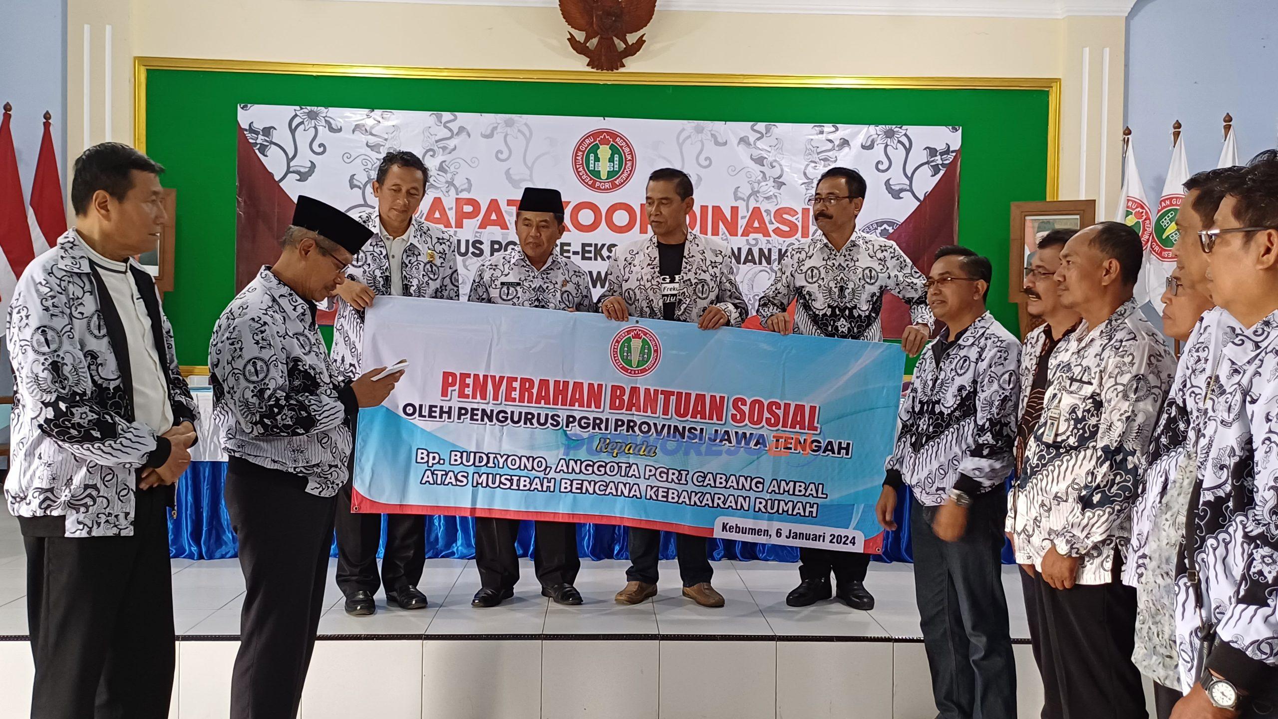 Pengurus PGRI Jateng saat memberikan bantuan sosial kepada anggota PGRI Kebumen yang terkena musibah kebakaran rumah di sela acara Rapat Koordinasi PGRI se- Kedu di Gedung PGRI Kabupaten Purworejo, pada Sabtu (6/1/2023)