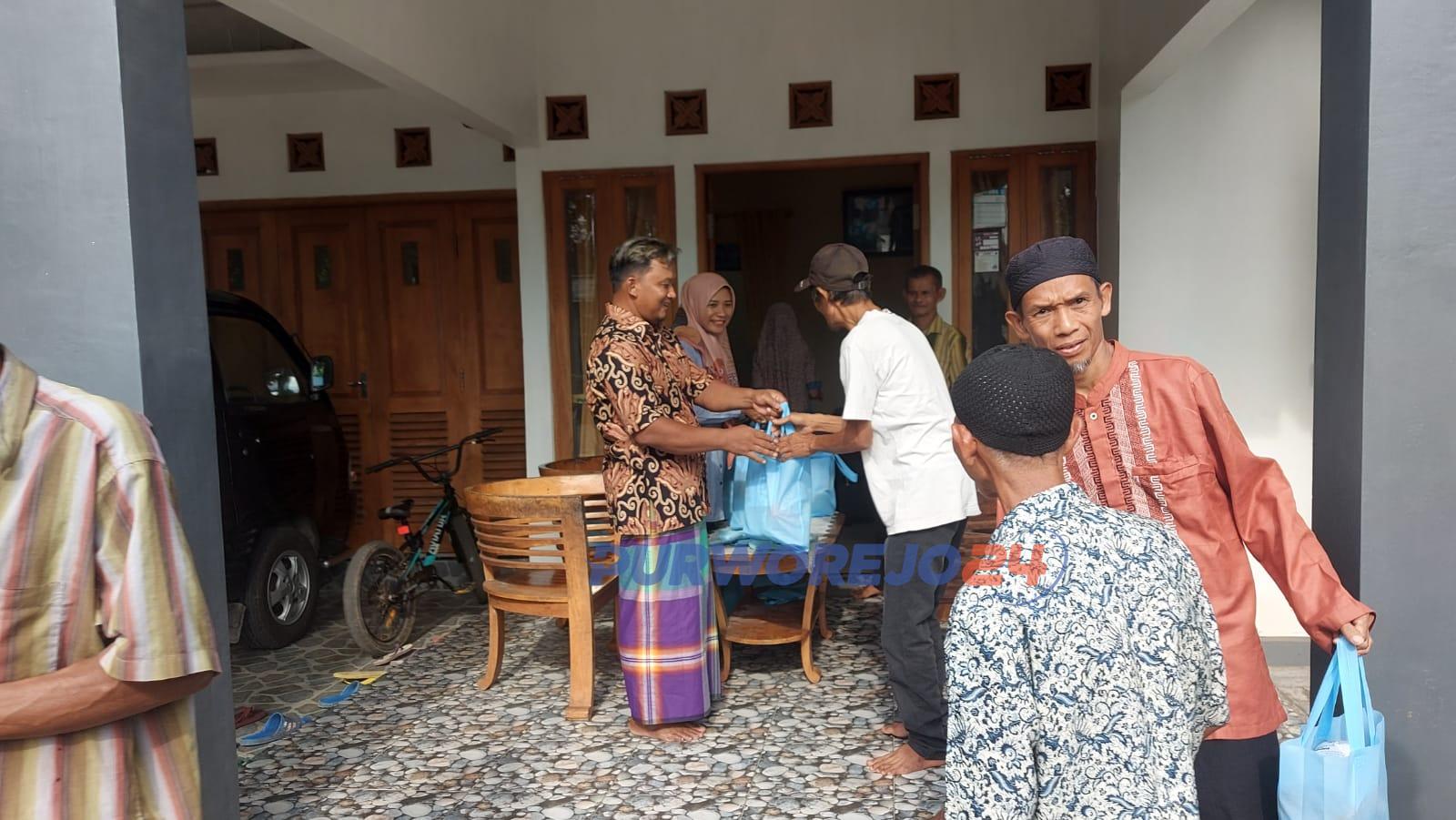 Seorang TNI bersama Istri saat membagikan sembako kepada warga