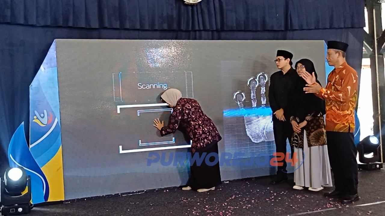 Bupati Purworejo menekan touchscreen membuka secara resmi Panen Hasil Belajar 7 Program Guru Penggerak Angkatan 9 Kabupaten Purworejo, di Pendopo Agung Kabupaten Purworejo, pada Kamis (25/4/2024).