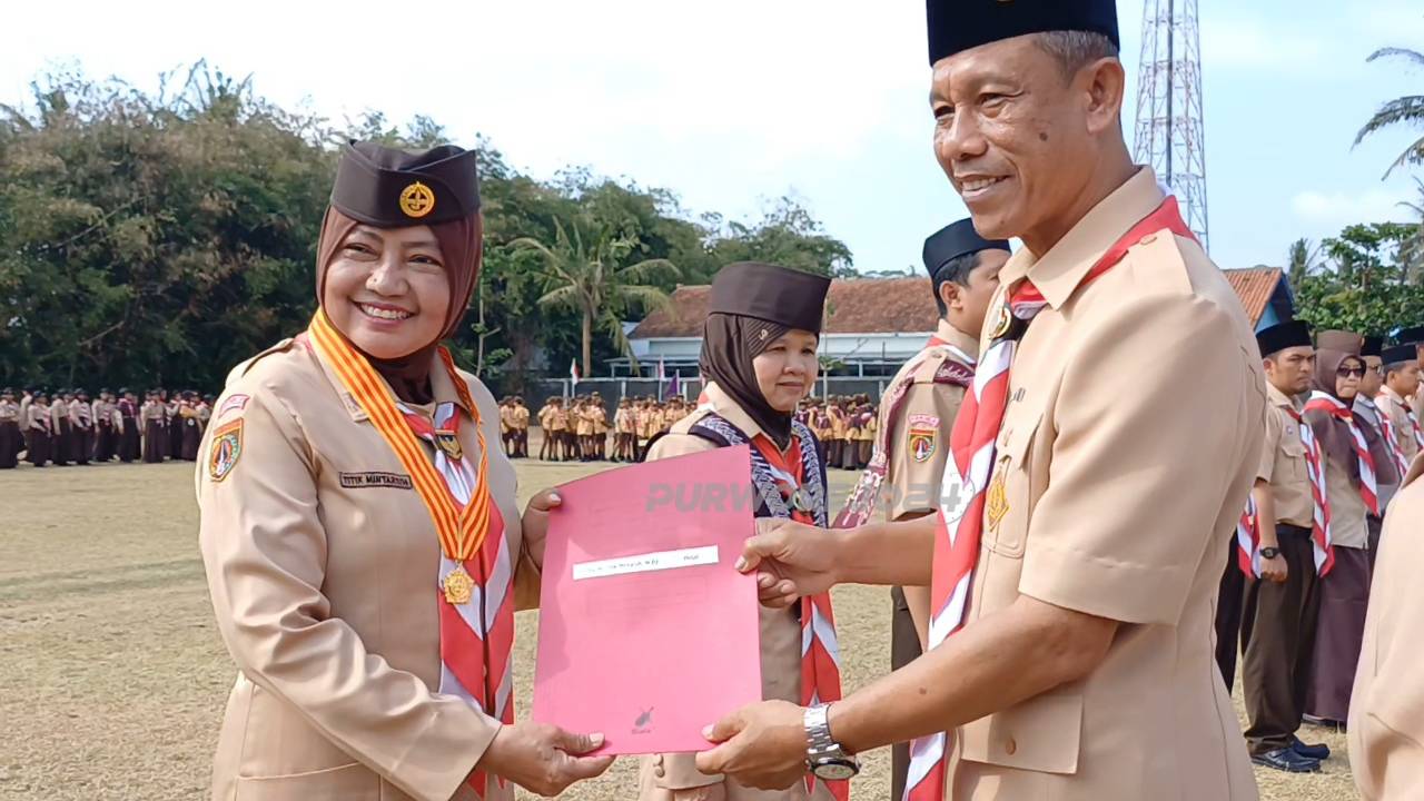 Tittik Mintarsih saat mendapat piagam dan lencana Melati dari Kwarnas yang diberikan oleh ketua Kwarcab Purworejo, Wasit Diono, dalam upacara Hari Pramuka ke-63, di lapangan Eks Kawedanaan Purwodadi, pada Rabu (21/8/2024)