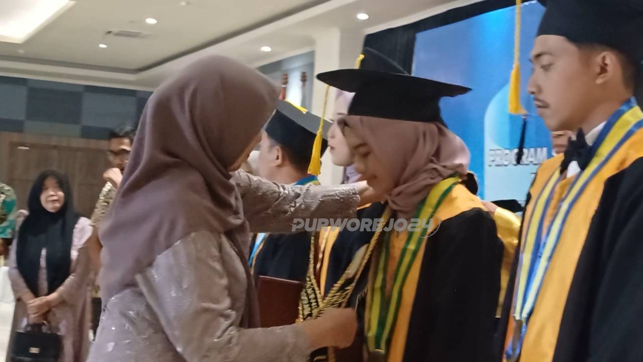 Pemberian selempang kepada lulusan wisudawan terbaik