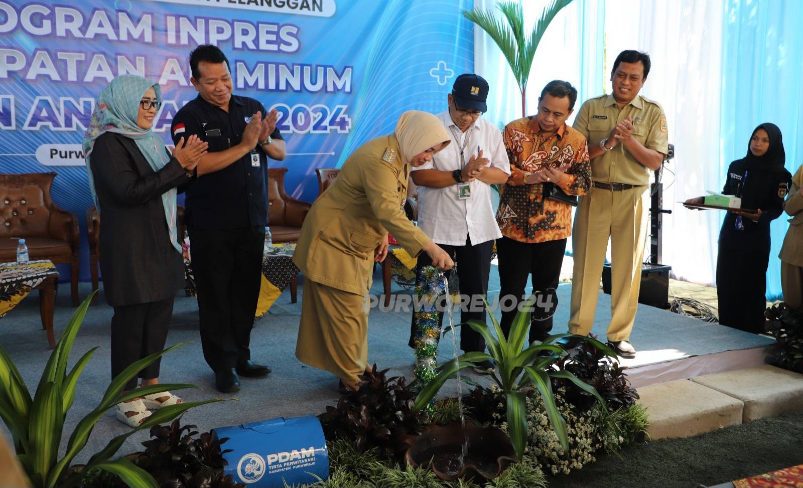 Bupati membuka kran air sebagai tandai launchingPelayanan Air Minum bagi Pelanggan Program Inpres Percepatan Air Minum Tahun Anggaran 2024