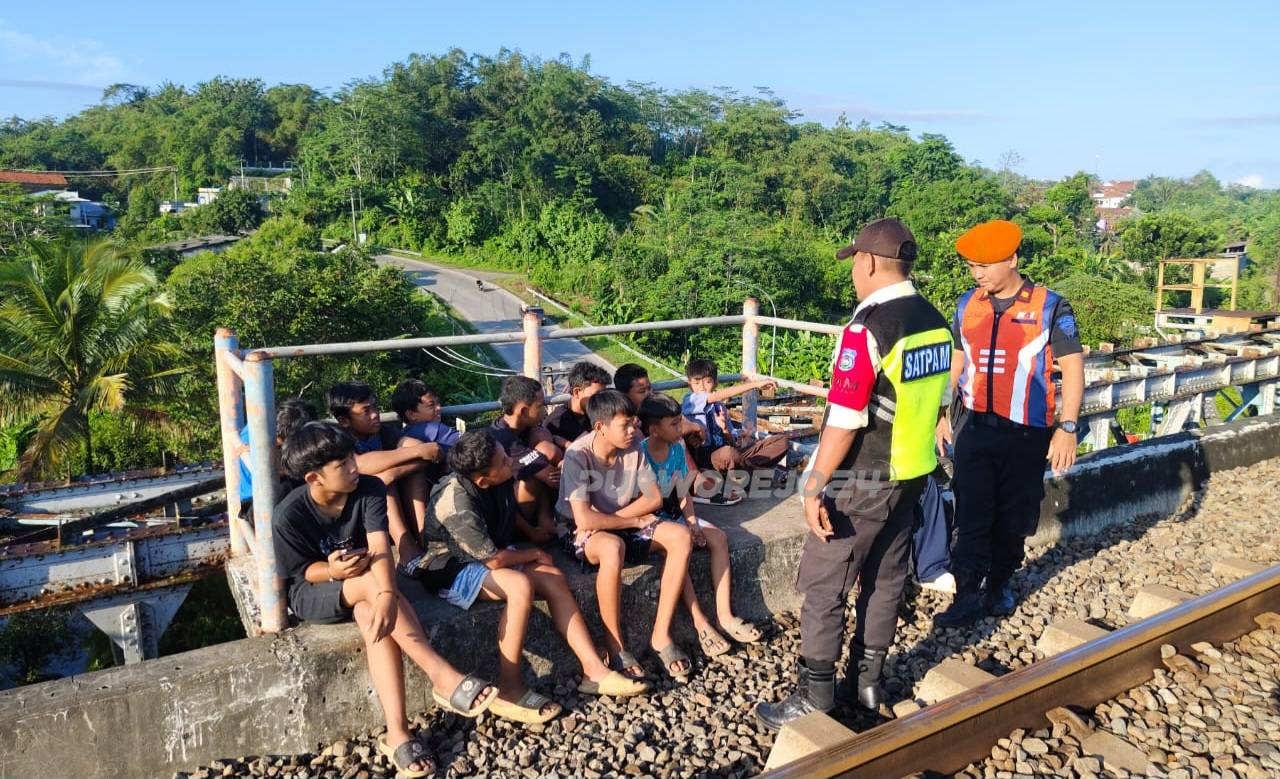 Petugas saat memberikan himbauan kepada warga untuk tidak bermain di tepi rel kereta api