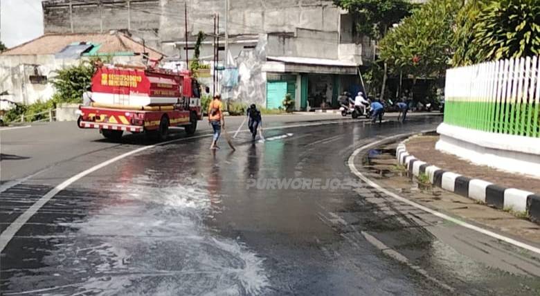 Petugas saat membersihkan tumpahan solar di Jalan Ahmad Yani Purworejo
