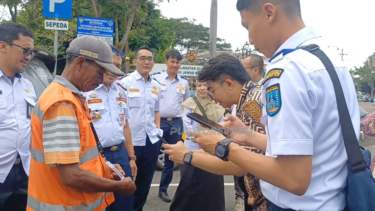 Petugas Dishub Salatiga saat bertemu dengan salah satu juru parkir di alun alun Purworejo dan mencoba pembayaran dengan QRIS