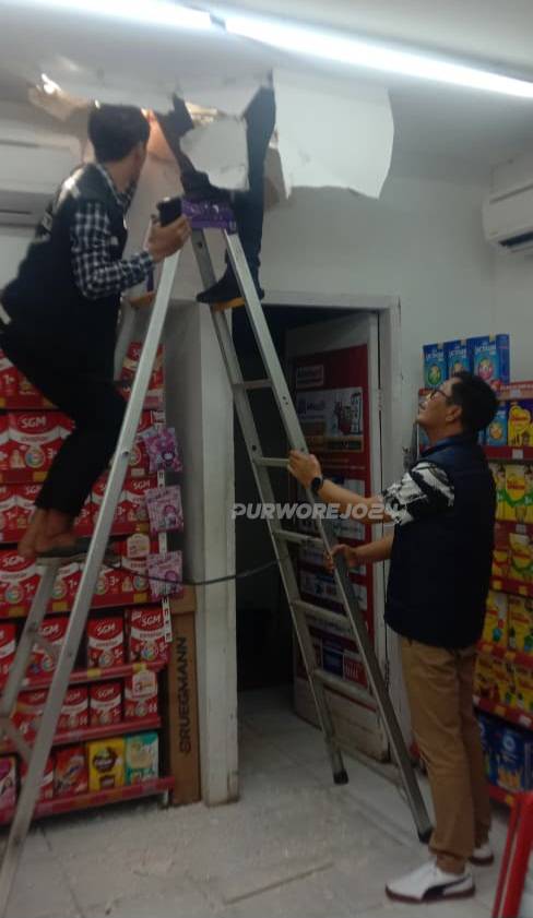 Petugas saat memeriksa plafon alfamart yang dijebol oleh pencuri
