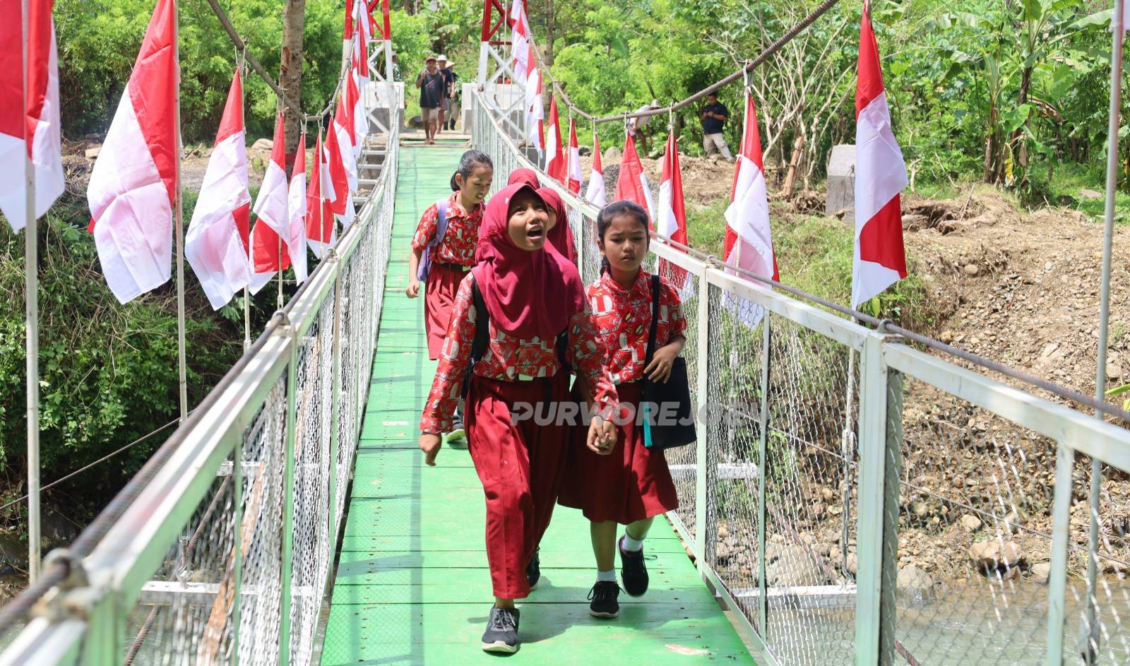 Sejumlah siswa saat melintasi Jembatan Gantung Garuda di Desa Plipir