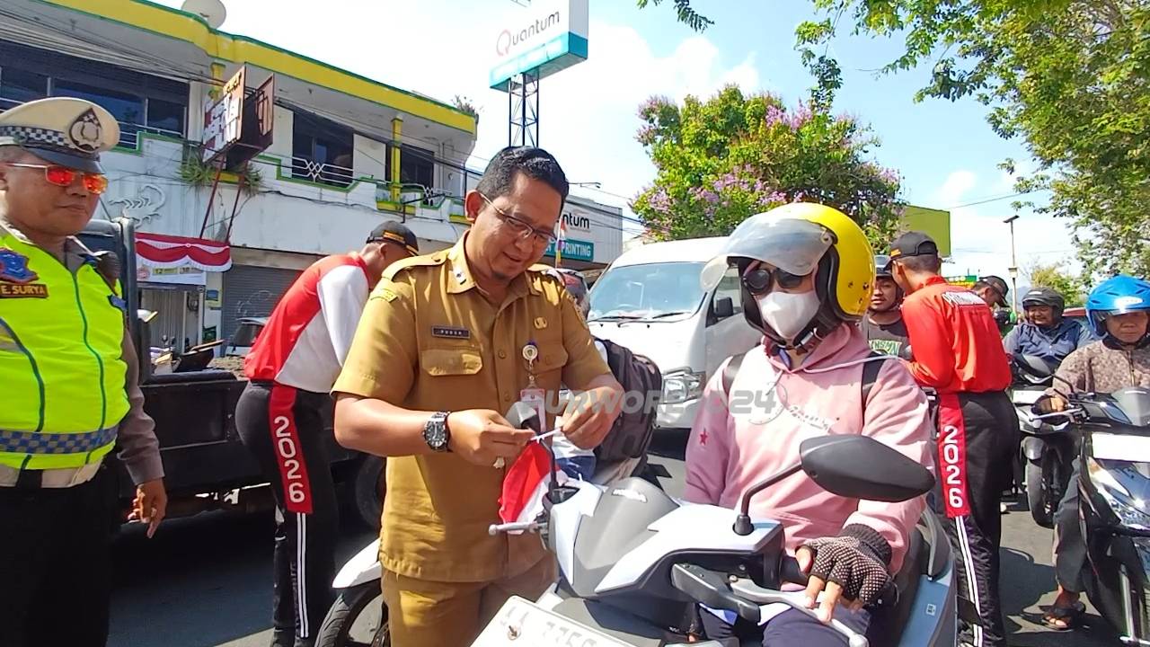 Kepala Kesbangpol Kabupaten Purworejo, Puguh Trihatmoko, S.H., M.H. saat memasangkan bendera merah putih ke salah satu pengendara