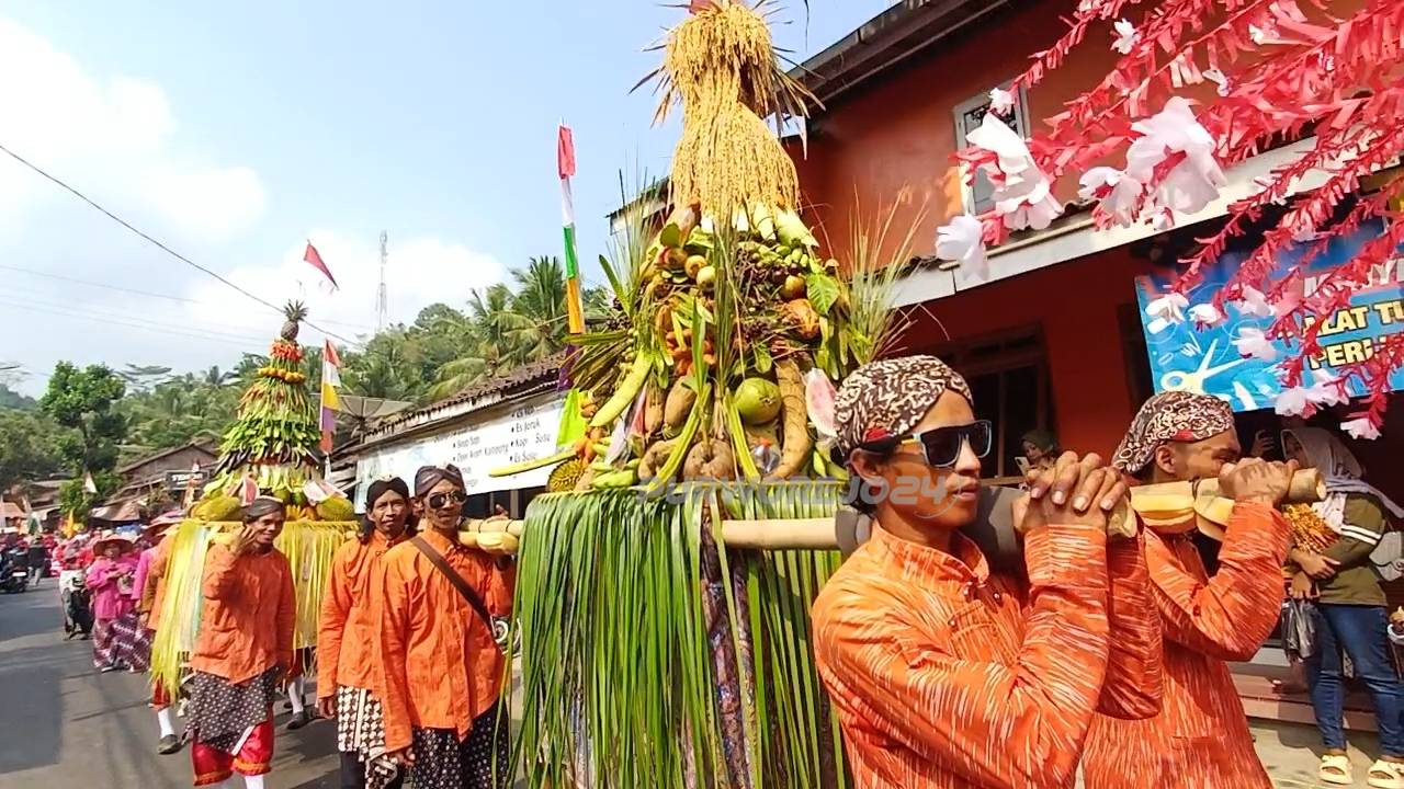 Warga membawa gunungaan hasil bumi dalam karnaval HUT ke 81 RI di Desa Banyuasin Kembaran